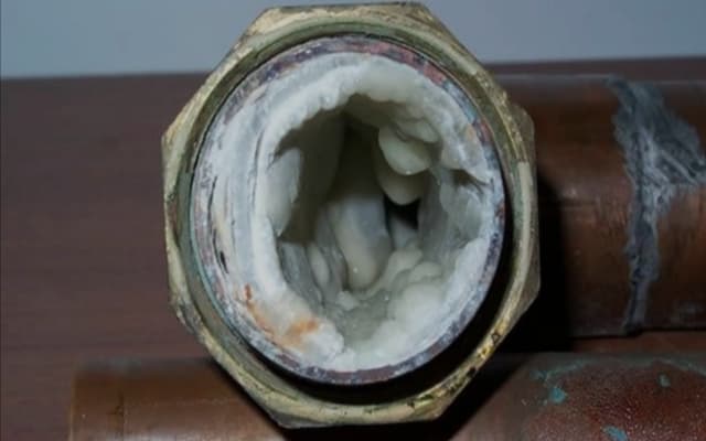 Tubería atascada con acumulación de cal en su interior